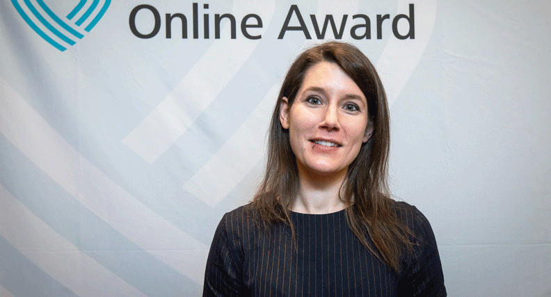 Katrin Ahäuser steht vor eine Pressewand des Grimme Online Awards
