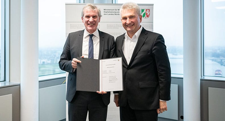 Professor Hubert Otten erhält den Förderbescheid aus den Händen von Wirtschaftsminister Professor Andreas Pinkwart.