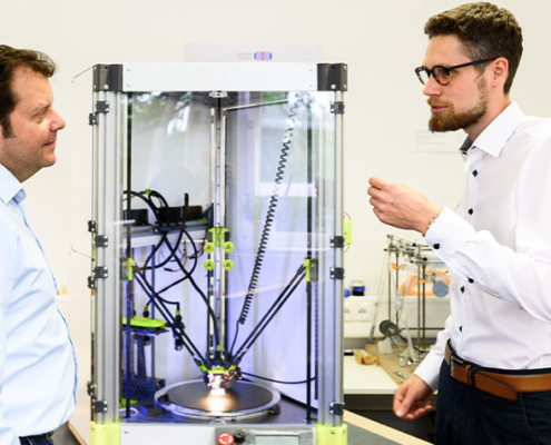3D-Druck ist an der Hochschule Coburg in vielen Bereichen Thema: Bei Prof. Dr. Markus Stark (links) hat beispielsweise Gründer Adrian Beetz (rechts) in seiner Masterarbeit diesen innovativen 3D-Drucker entwickelt.